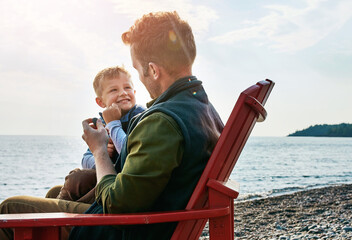 Wall Mural - Beach, smile or vacation with dad and son on chair by ocean for bonding, island holiday or travel together. Children, family or love with single parent man and boy child outdoor by sea to relax