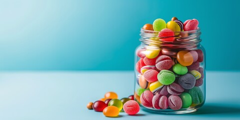 A jar full of colorful candies. The candies are in different shapes and sizes, and they are all mixed together. The jar is on a blue surface, and the candies are scattered around it