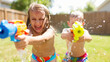 © master1305 - Two kids having fun in the backyard on a sunny summer day, joyfully playing with colorful water guns