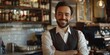 © vefimov - A man stands with his arms crossed in front of a bar, ready to socialize