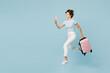 © ViDi Studio - Traveler happy woman wear casual clothes hold mobile cell phone bag jump high isolated on plain blue background. Tourist travel abroad in free spare time rest getaway. Air flight trip journey concept.