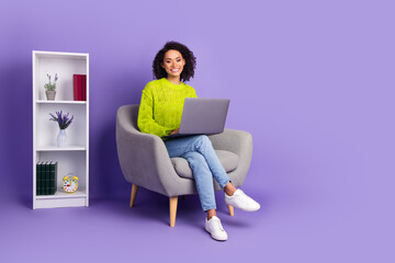 Wall Mural - Full length photo of lovely young lady sit armchair netbook office work dressed stylish green garment isolated on violet color background