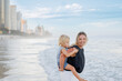 © Austockphoto - Mother giving son piggy back ride on Main Beach, Surfers Paradise on the Gold Coast
