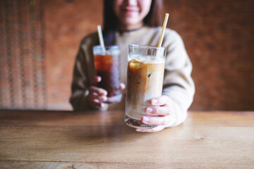 Canvas Print - Closeup image of a young woman holding andserving two glasses of iced coffee