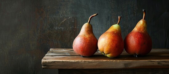 Canvas Print - Ripe pears displayed on a wooden table with a dark background, providing a copy space image.