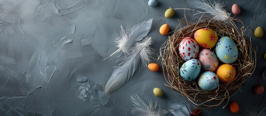 Aufkleber - Close-up of a decorative nest featuring painted Easter eggs on a gray backdrop with feathers, perfect for a copy space image.