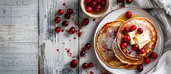 Poster - A flat lay of cereal pancakes with cranberries and butter on a white wooden table, providing room for a text message in the copy space image.