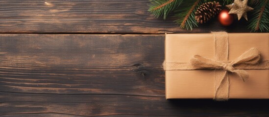 Aufkleber - Top view of a handcrafted Christmas gift box in kraft paper on a wooden surface, with ample copy space for text, accompanied by a greeting card.