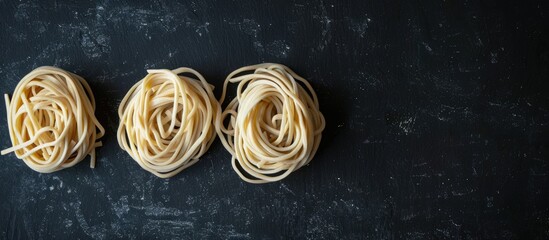 Poster - Top-down photo of three udon noodle nests on a black background with a copy space image.