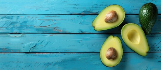 Poster - Avocado positioned on a blue wooden backdrop with space for text or design.