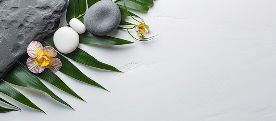 Aufkleber - Top view of a spa concept with palm leaves, flowers, candles, and gray stones on a white stone background with room for text, copy space image.
