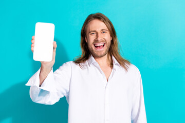 Wall Mural - Photo of cheerful positive guy dressed white shirt showing modern device emtpy space isolated turquoise color background