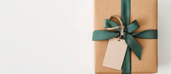 Aufkleber - A plain brown gift box adorned with a green raffia ribbon and a label, all set against a white backdrop, ideal for a copy space image.