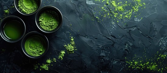 Aufkleber - Top view of a black background displaying a bowl of matcha tea powder beside cups filled with the drink, offering copy space image.