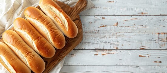 Poster - Overhead view of hot dog buns on a rustic wooden board with a white wooden background, depicted in a flat lay style from above, offering ample copy space image.