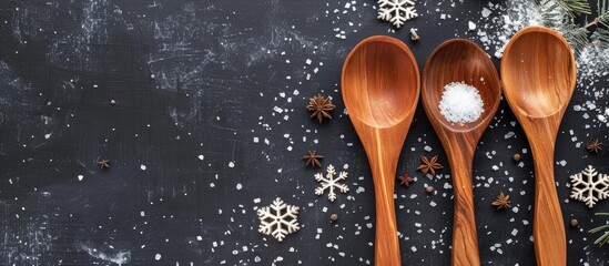 Poster - three wooden cooking spoons arranged on a black background decorated for the holidays with snowflake