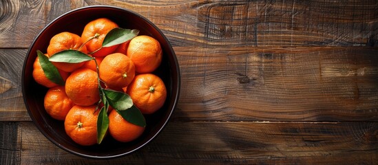 Poster - Bowl filled with sweet tangerines on a wooden backdrop with ample copy space image.