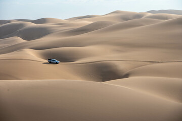 car driving on the sand dunes in the desert