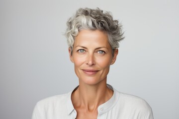 Poster - Mature woman with grey hair smiling and looking at camera over grey background