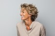 © Stocknterias - Portrait of a beautiful smiling woman with blond hair on grey background