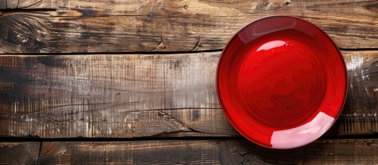 Poster - View of a red plate on wood background with copy space image for design