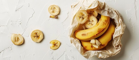 Fototapete - Banana and dried slices in a bag with ample copy space on a white backdrop