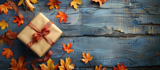 Poster - Autumn themed composition featuring a gift box maple leaves and a festive ribbon bow set on a rustic wooden table with copy space image perfect for autumn sale promotions