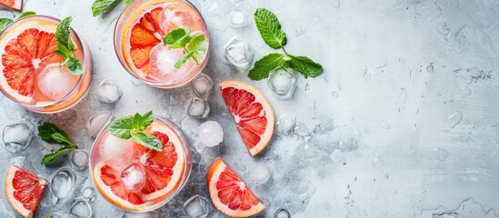 Poster - Tasty cocktails made with grapefruit mint and ice balls on a white table with copy space image available