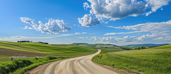 Poster - A rural summer scene with a country road set amidst green hills under a blue sky perfect for a copy space image