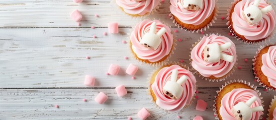 Poster - Top view copy space image showing festive Easter treats homemade cupcakes decorated as cute bunny rabbits with cream and marshmallow paws on a white wooden table