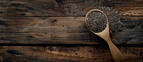 Wall Mural - Spoon holding chia seeds against a wooden table with a plain background suitable for copy space image