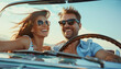 © Chlorophylle - Couple amoureux et heureux dans une voiture décapotable vintage faisant un voyage en vacances avec les cheveux aux vents