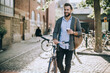 © Geber86 - Man Drinking Coffee and Walking with Bicycle in City