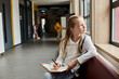 © LIGHTFIELD STUDIOS - A young girl with a focused expression sits on a window sill, writing in a notebook as sunlight streams in through the glass pane.