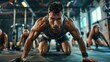 © radekcho - A high-intensity interval training class in a modern gym, with participants performing burpees under the guidance of an energetic man instructor.