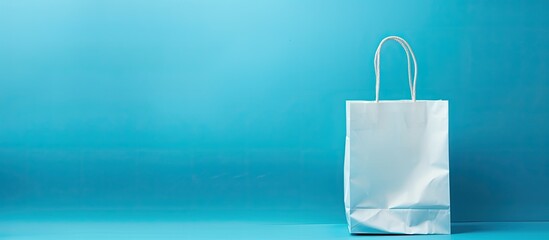 Aufkleber - Shopping concept illustrated by a white shipping bag against a blue background with copy space image