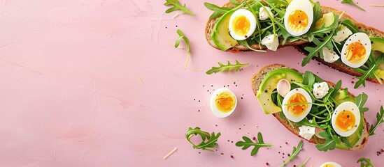 Aufkleber - Delicious sandwiches featuring avocado arugula boiled eggs and mozzarella cheese on fried toast displayed on a pink background with a perfect copy space image
