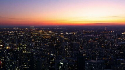 Aufkleber - An aerial view of a city at sunset, showing the cityscape bathed in the golden light of dusk.