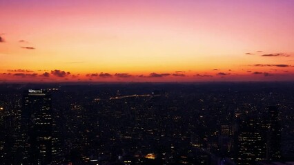 Poster - A city skyline is illuminated by the golden hour light of a setting sun.