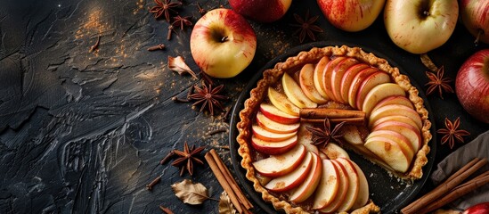 Leinwandbilder - Close up top view of a homemade fruit tart with golden crust featuring whole and halved apples cinnamon sticks and anise seeds against a background with copy space image
