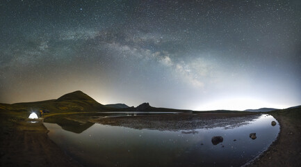 Wall Mural - beautiful night landscape, small lake in the mountains under bright milky way galaxy.
