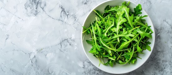 Poster - A bowl with fresh arugula displayed on a light grey marble tabletop in a flat lay composition with ample space for adding text