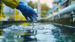 © PAPAGAP - Scientist hand in glove collecting water sample in laboratory for testing and analysis, water quality research, environmental protection.