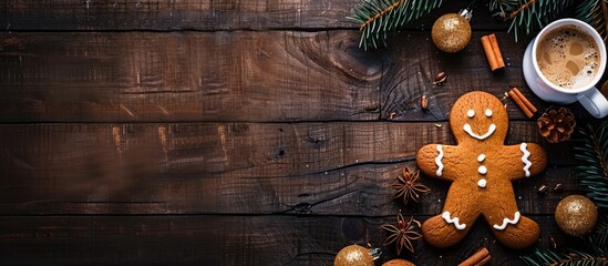 Canvas Print - Gingerbread man beside coffee spruce branch and festive decor on a dark wooden surface in a top down view with copy space image