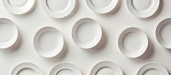 Wall Mural - Empty ceramic plates arranged with copy space image on a white background in a top down view