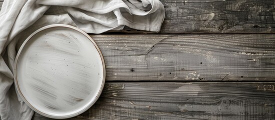 Poster - Napkin rests on empty plate on grey wooden table leaving copy space image