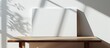 © Ilgun - Horizontal blank canvas on a wooden table against a white wall with shadows suitable for adding content in the copy space image