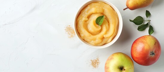 Poster - Concept for organic baby food featuring a bowl of apple and pear puree with a fresh apple nearby on a white backdrop ideal for adding text in the copy space image