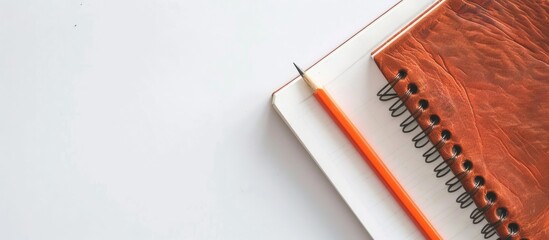 Poster - Notebook and pencil on a white backdrop with copy space image available