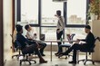 © alfa27 - Multiethnic corporate business team reporting the Head of department about the results of done work, gathering in spacy and airy conference room in office